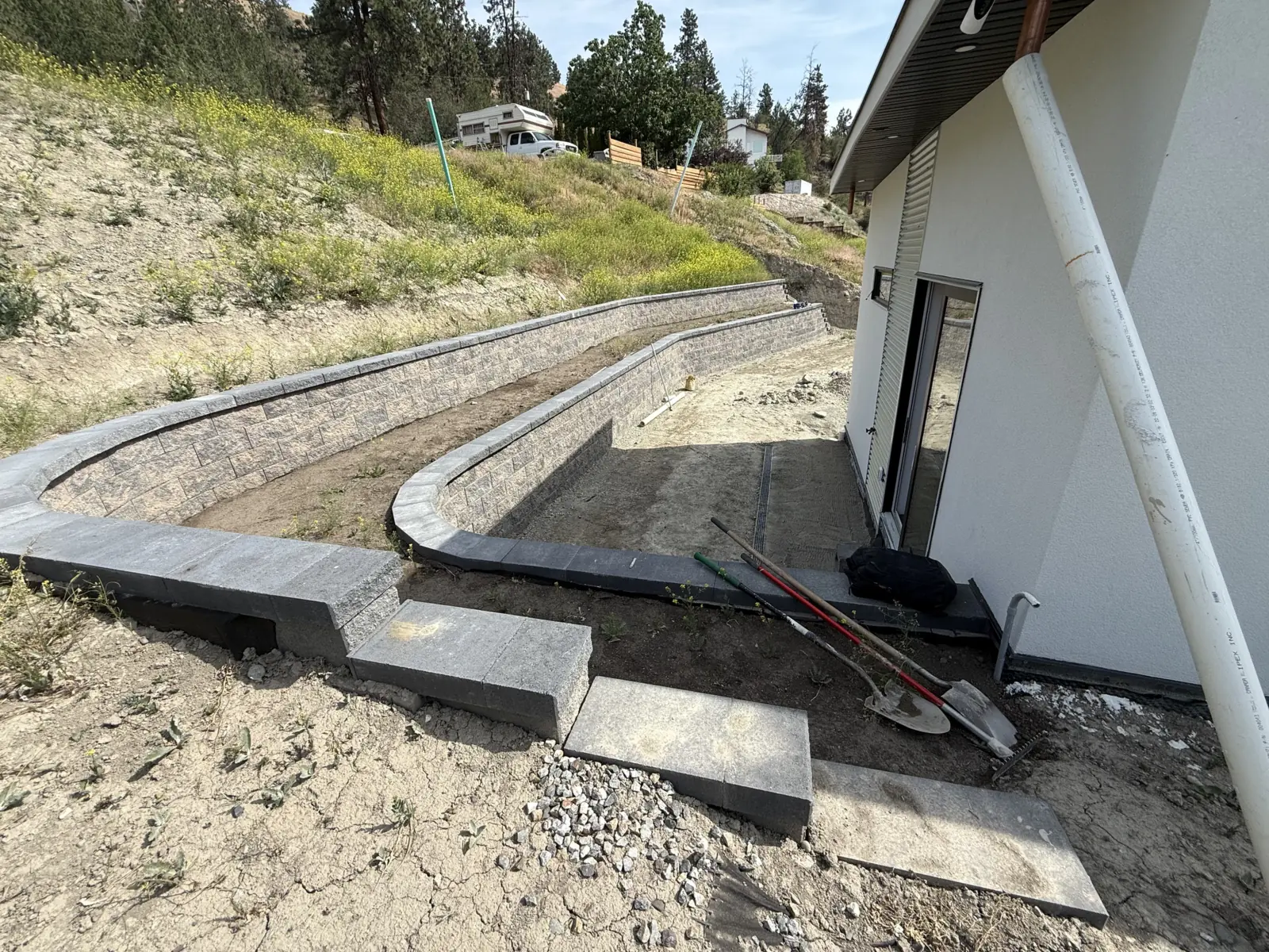Curved wall caps and step blocks going in beside the house