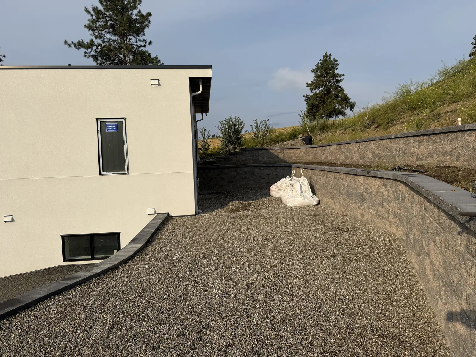 Block wall and gravel base along the side of a new home