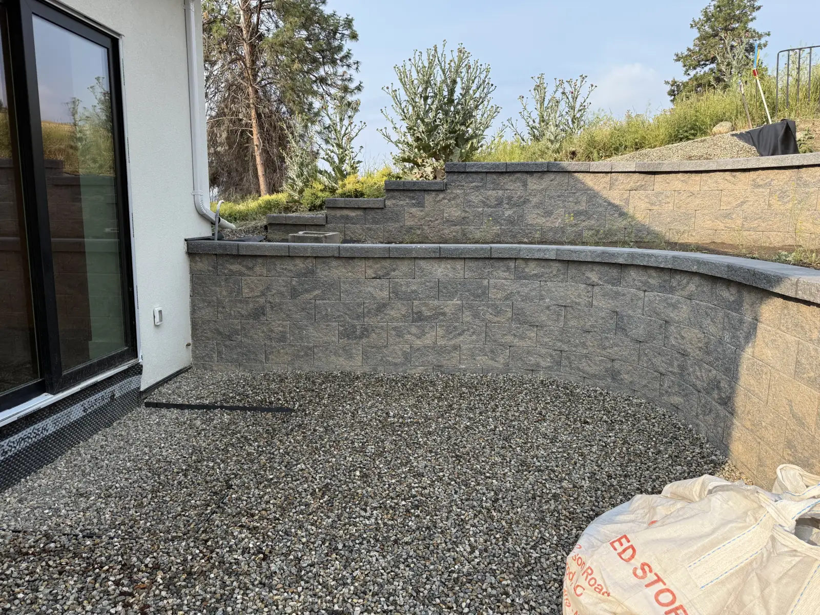 Curved block retaining wall with stepped walls above