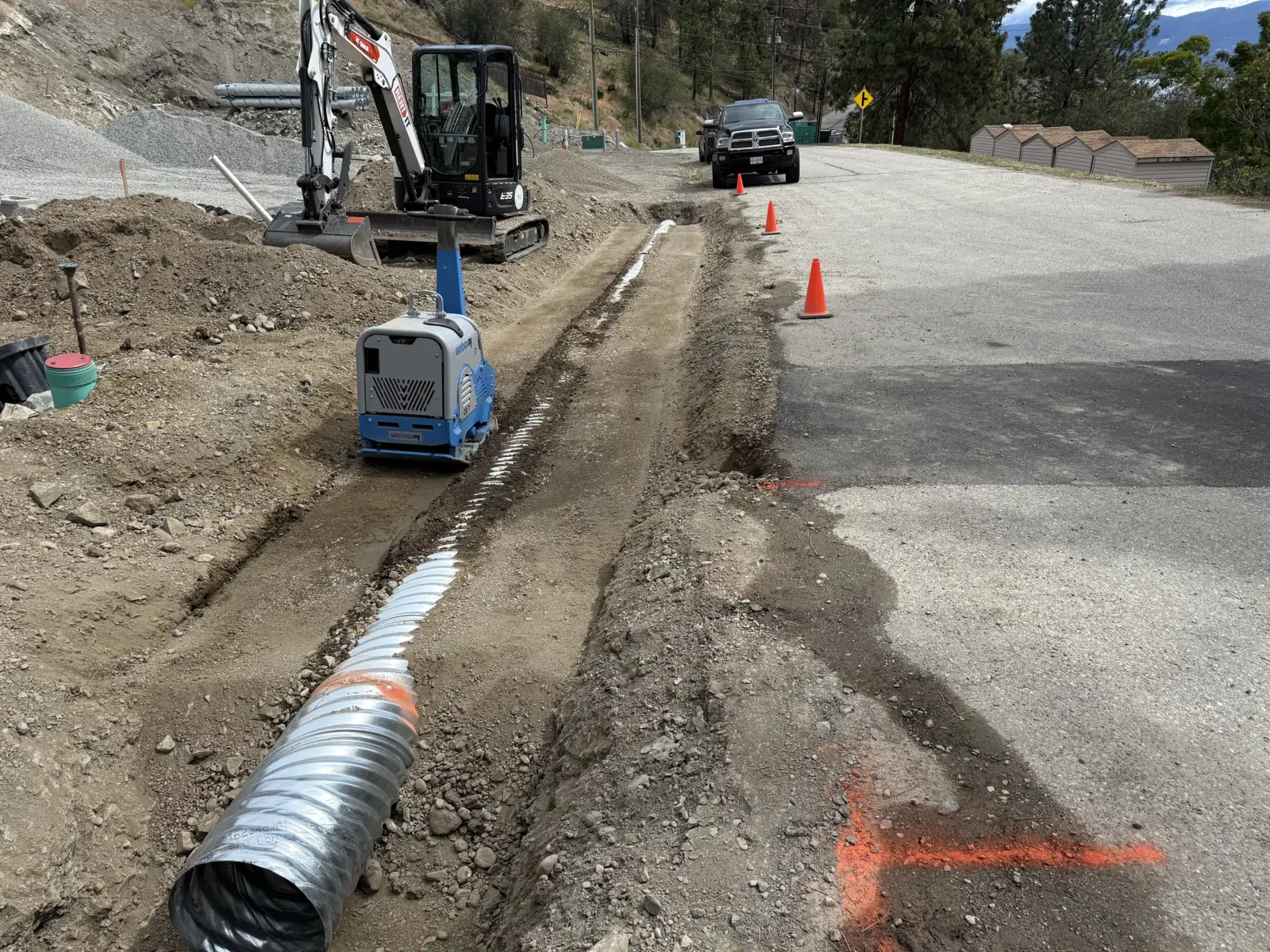 Culvert pipe laid in a ditch along a paved road