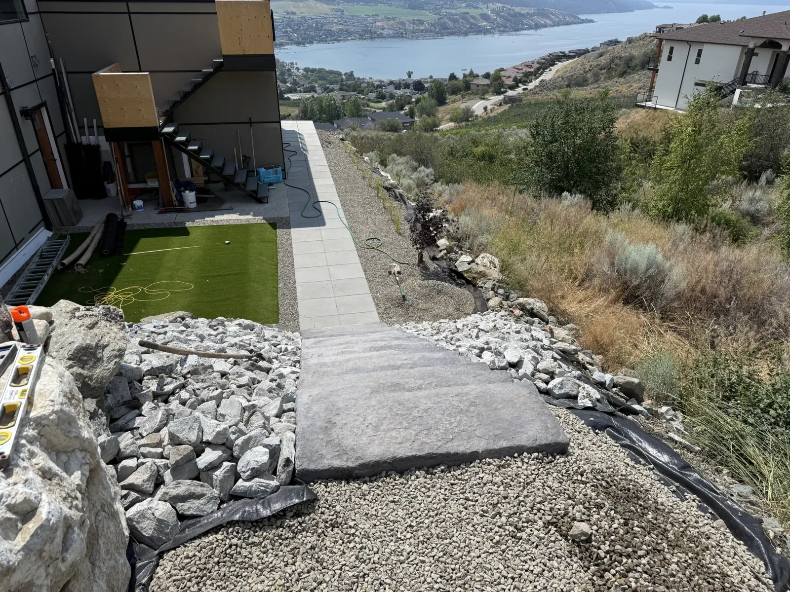 Paver walkway down the hillside beside turf, with the lake below