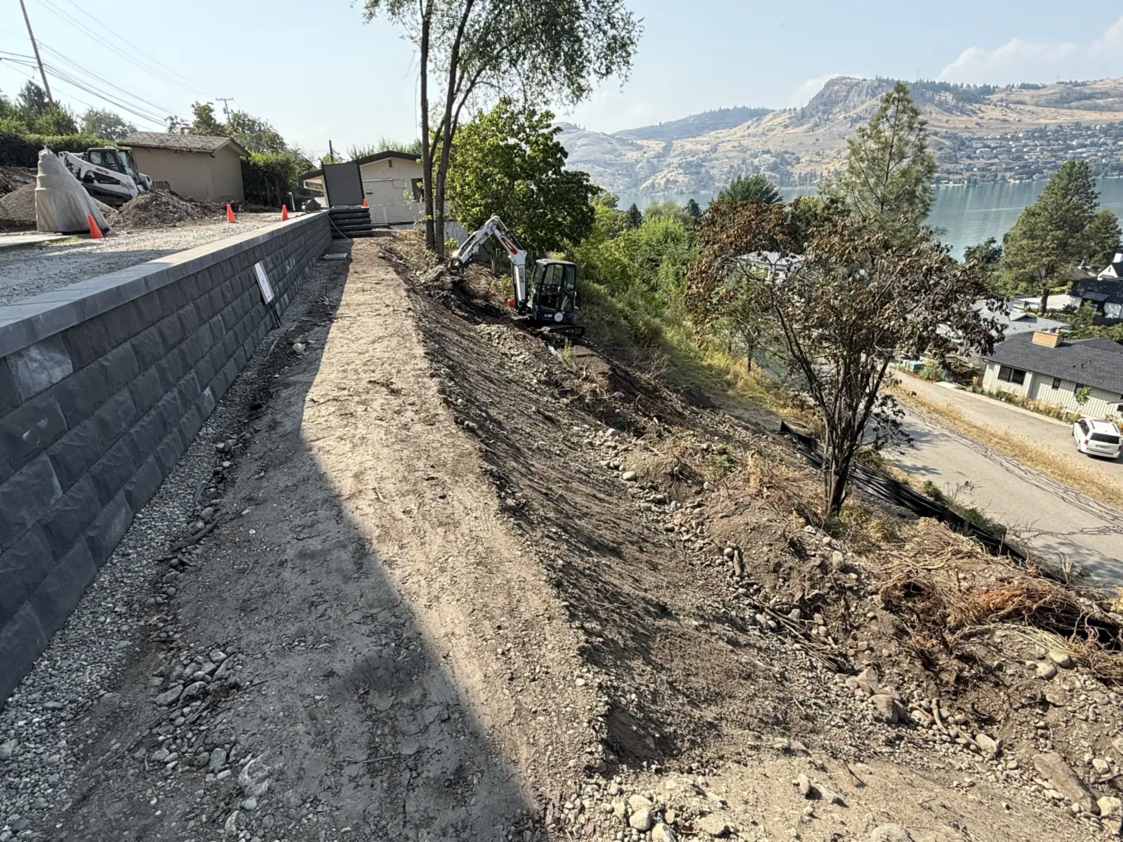 Block wall along the top of a slope with a lake view