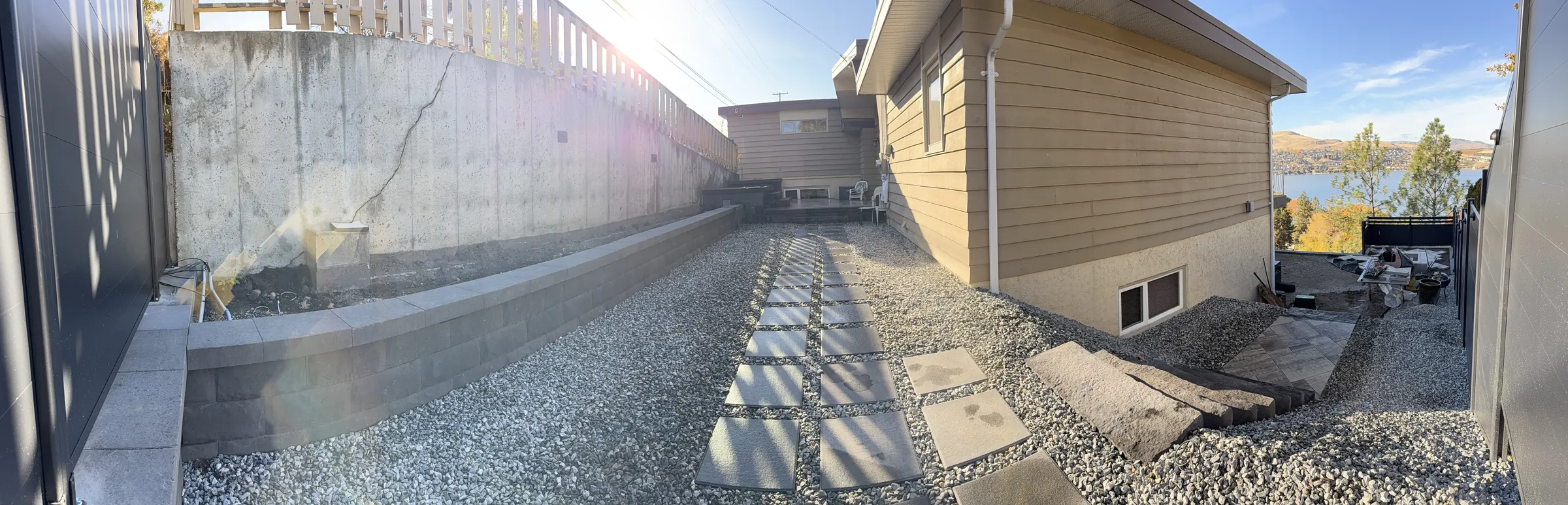 Panorama of the side yard with the block wall and stepping stone path