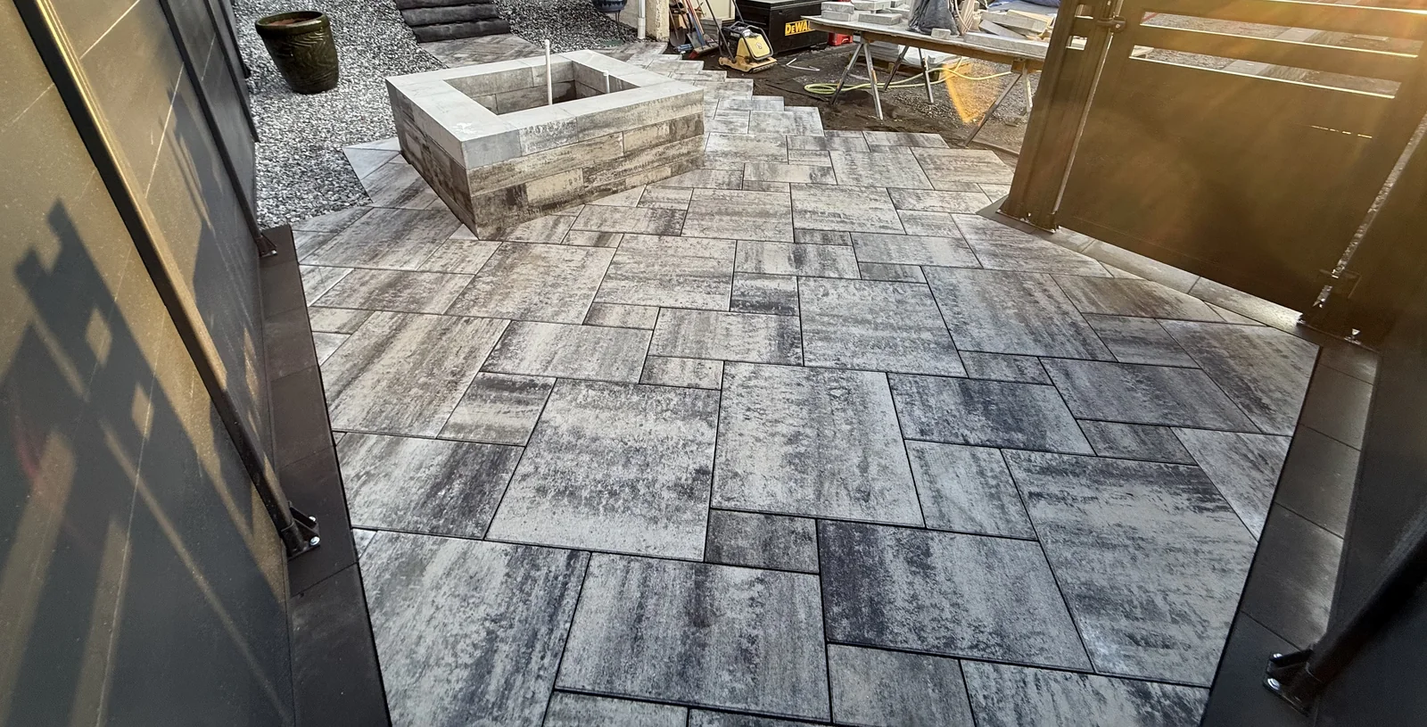 Large format paver patio around a built fire pit