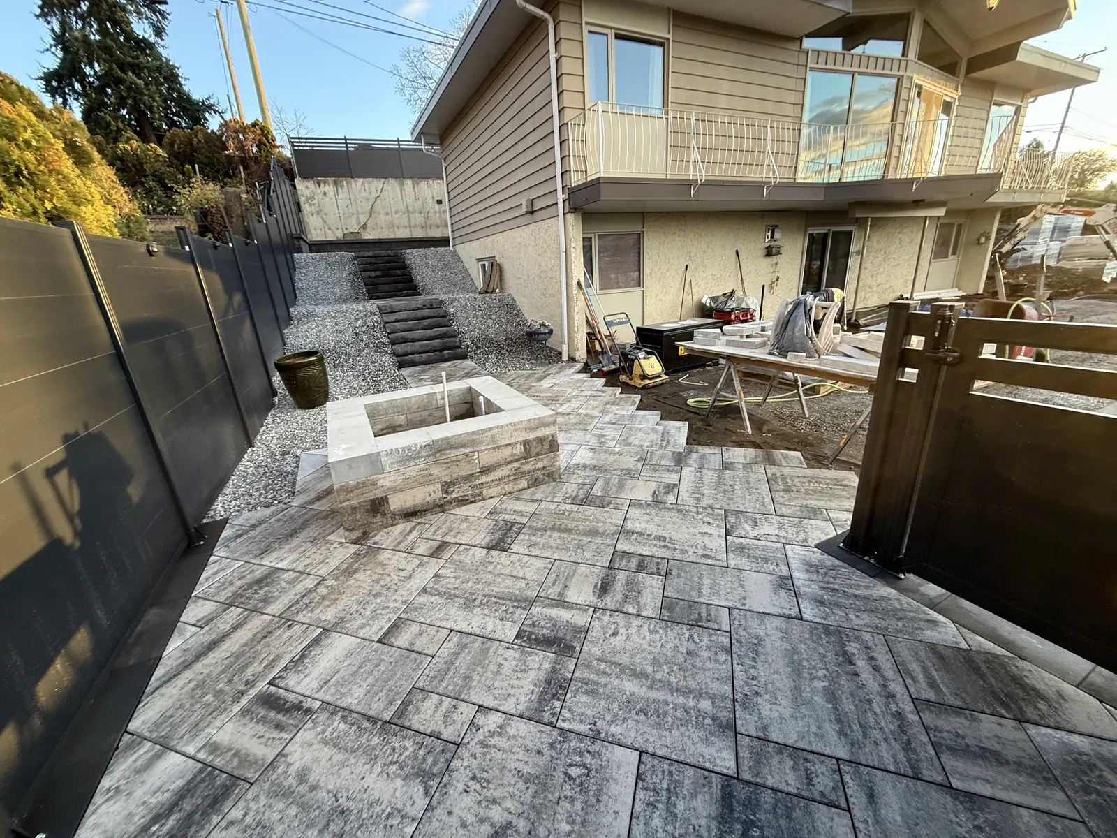 Finished paver courtyard between the house and a terraced side yard