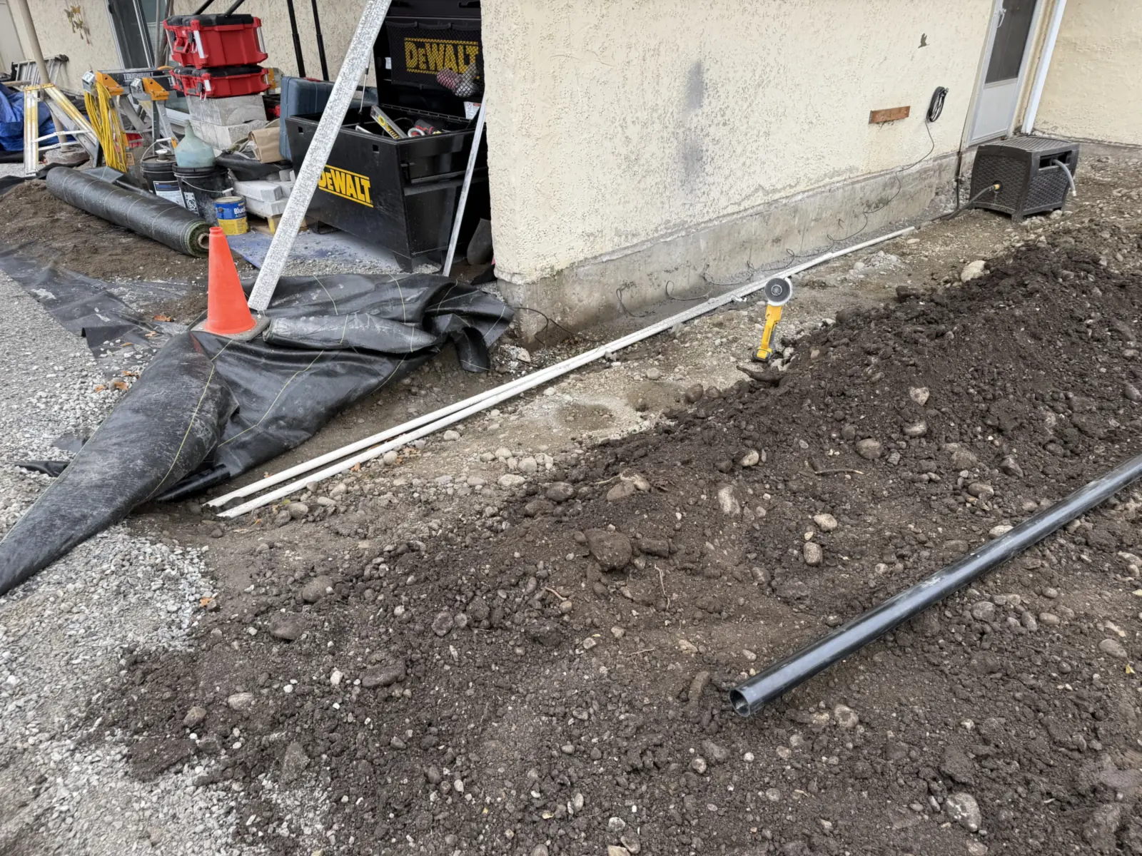 Pipe laid in the trench along the house before backfill