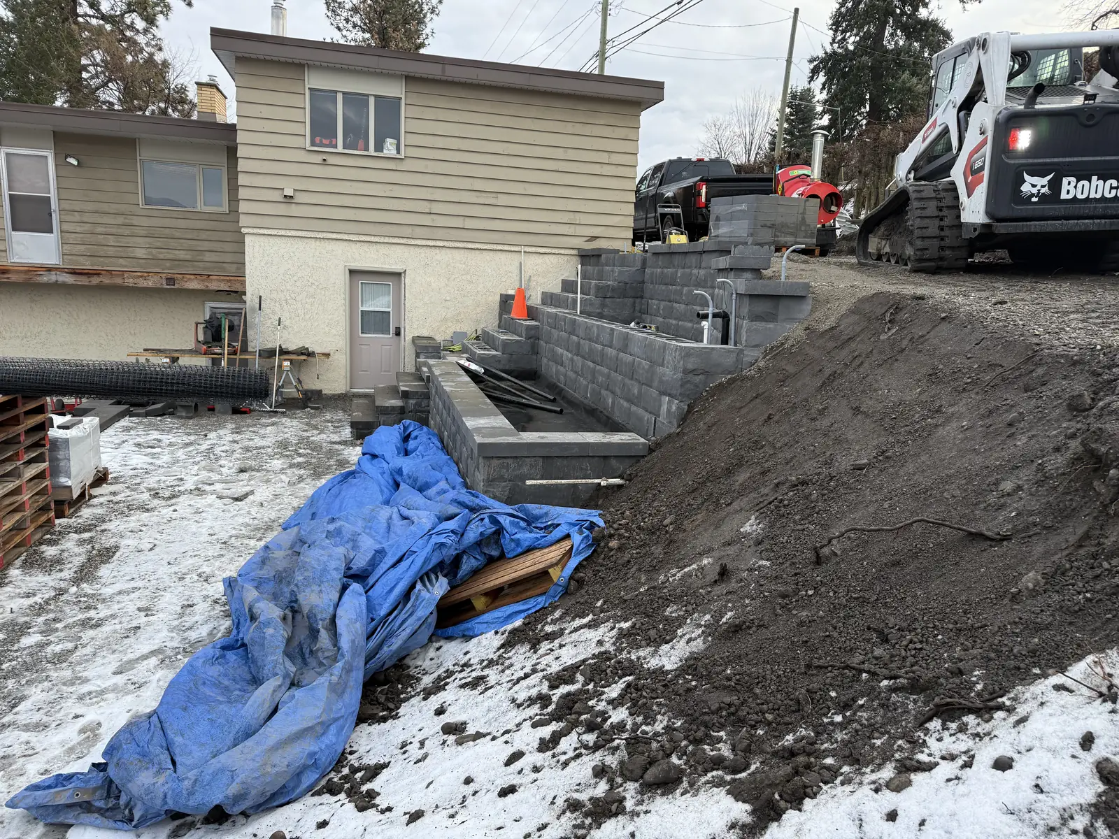 Block wall and stairs going in beside the house in winter