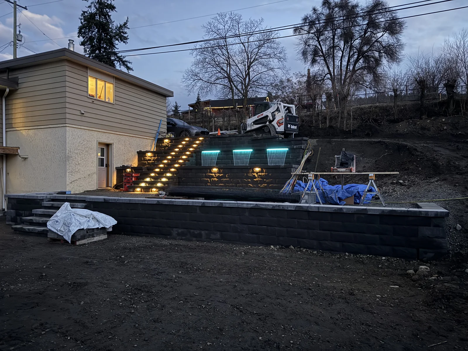 Terraced wall at dusk with the stair lights and water features on