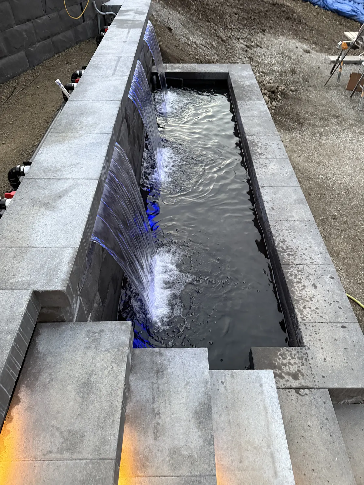 Water feature basin filling beside the cut stone steps