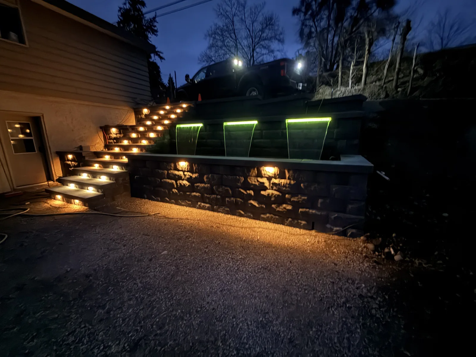 Colour changing LED water feature in green with warm lit stair treads