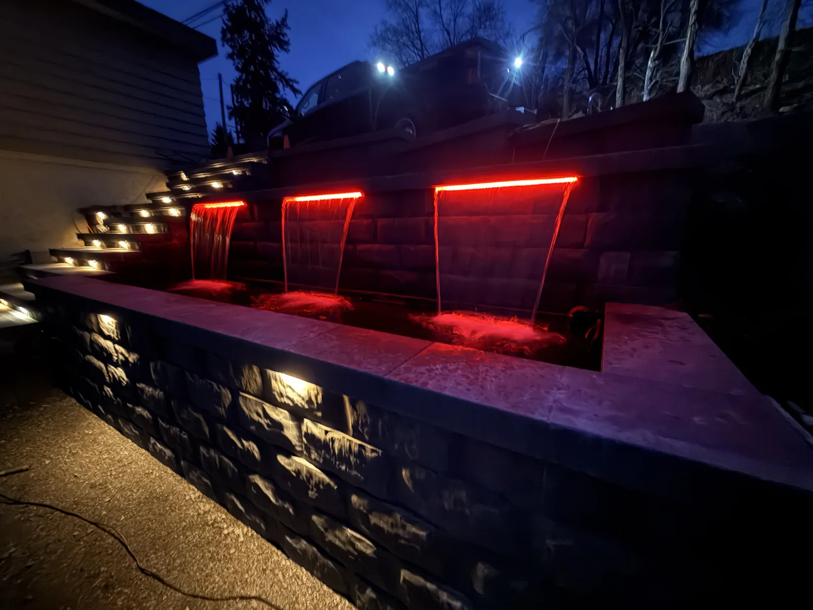 The same water feature wall lit red, showing the colour range