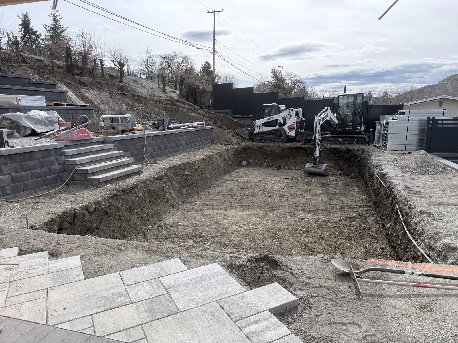 Pool excavation with the retaining walls and stairs above it