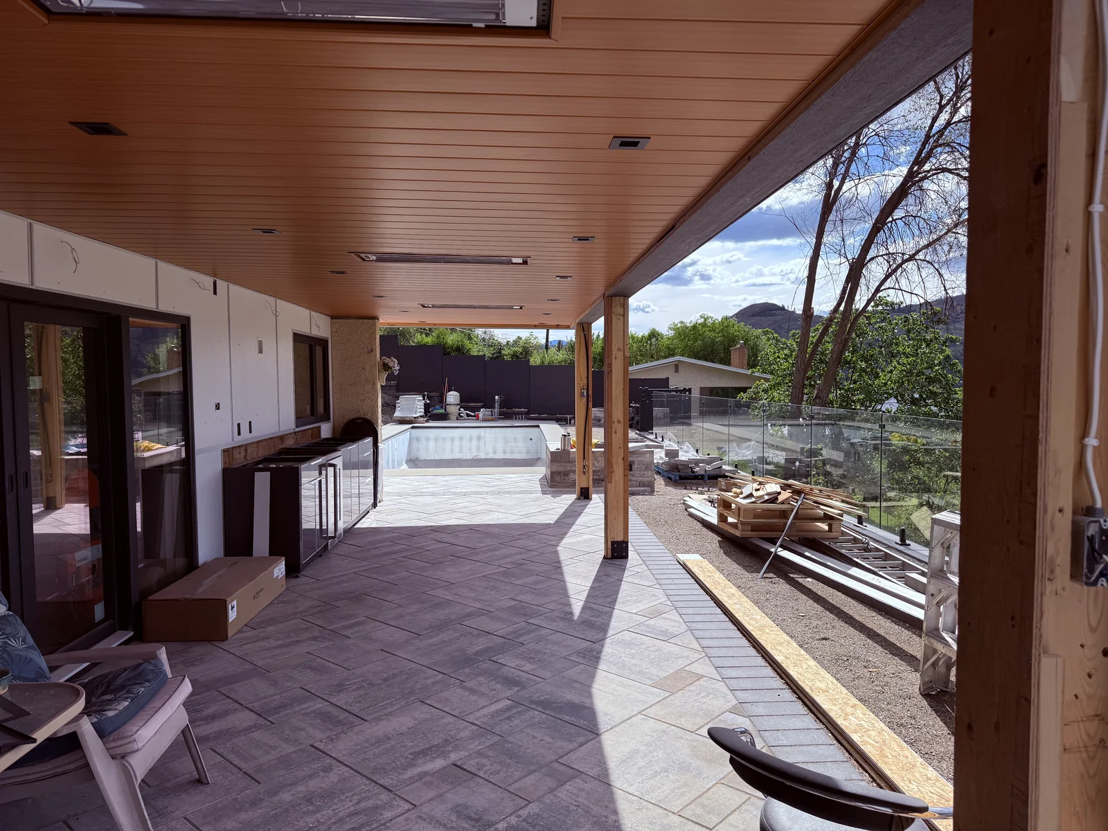 Covered patio in large format pavers looking out to the pool