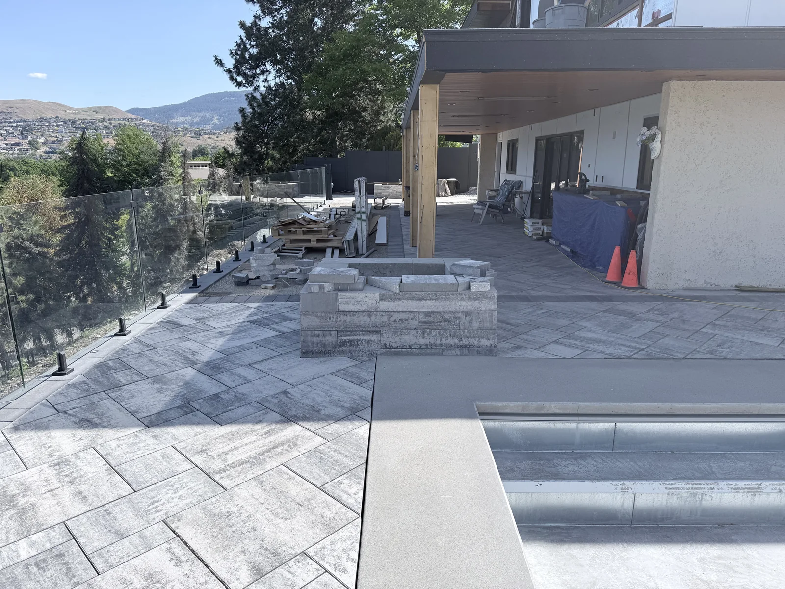 Glass railing, fire feature and pool deck laid in large format pavers