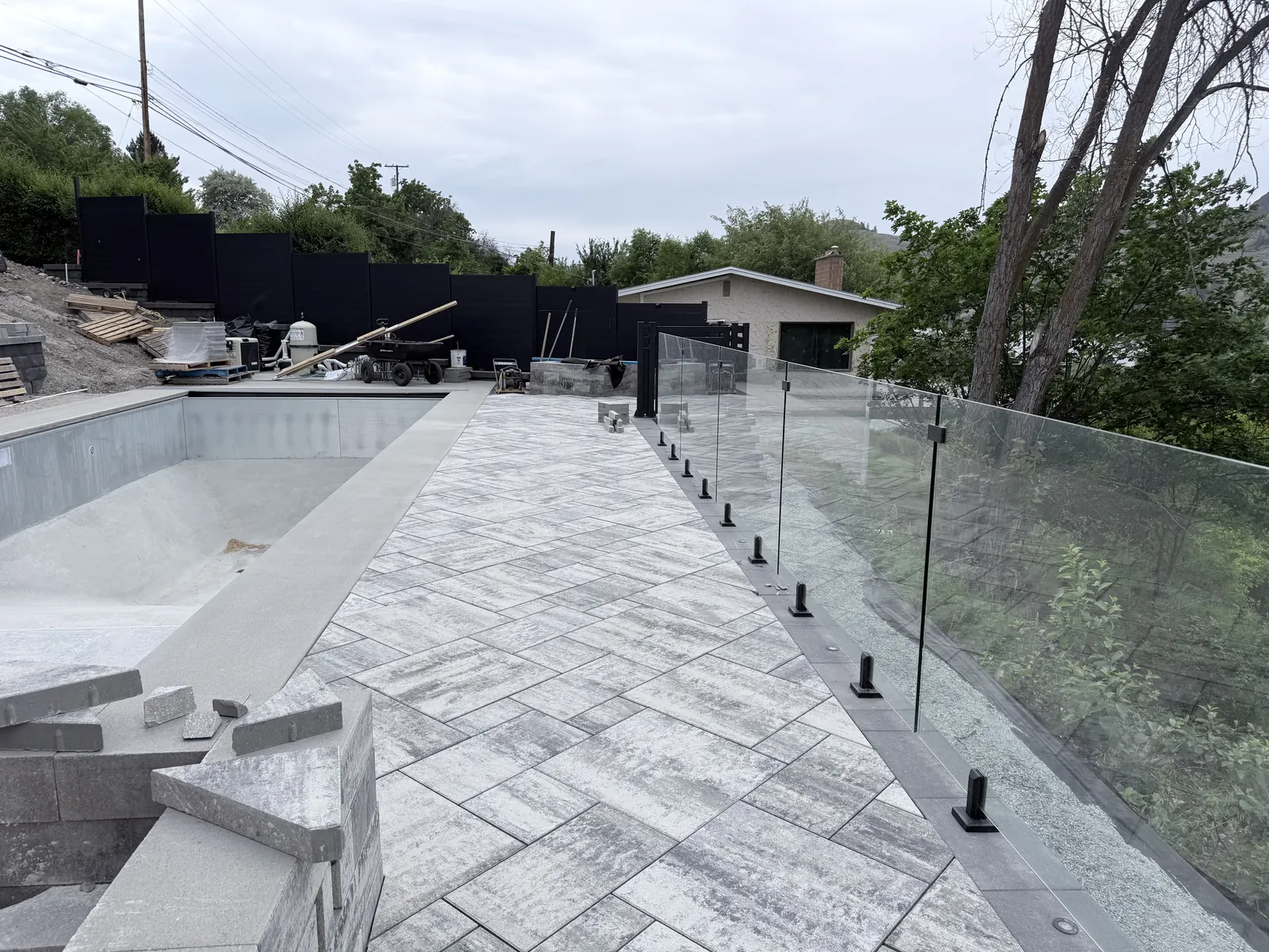 Frameless glass railing along the edge of the pool deck