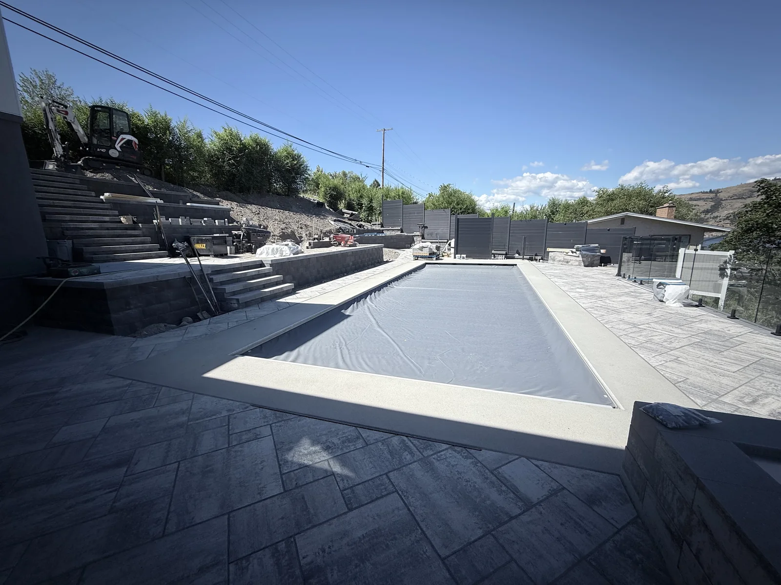 Pool, coping and paver deck with the retaining walls and stairs behind