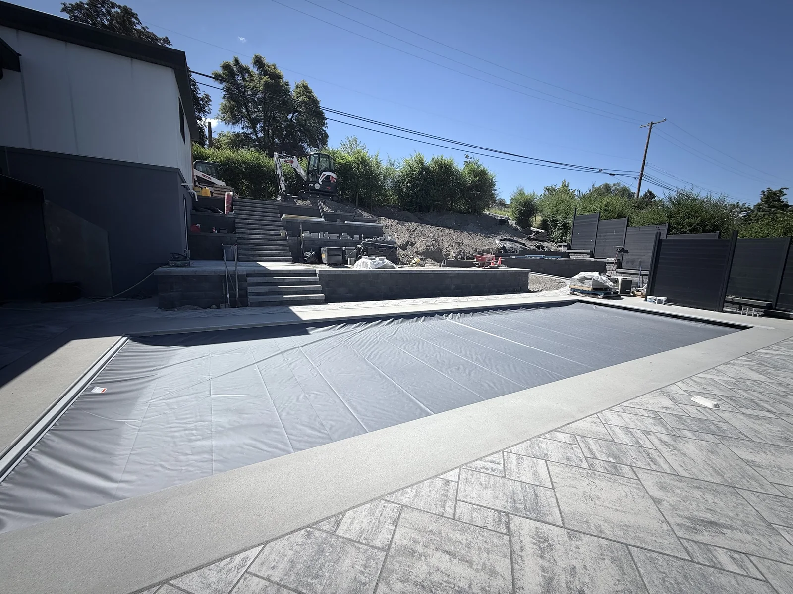 Pool deck in large format pavers with steps up to the upper terraces
